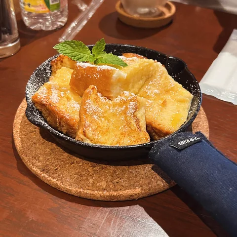 French toast in a cast iron skillet, dusted with sugar